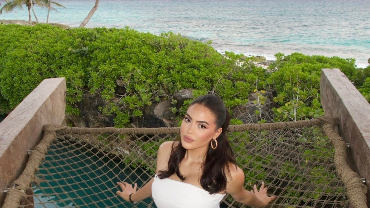 Founder of Cove and Curve sitting at the beach, representing swimwear brand for fuller busts and DD+ sizing